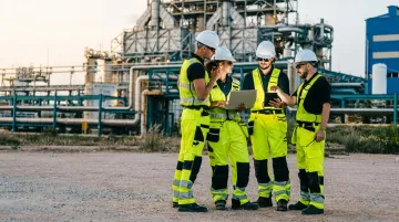 Energy sector workers in safety gear conducting field operations at industrial site
