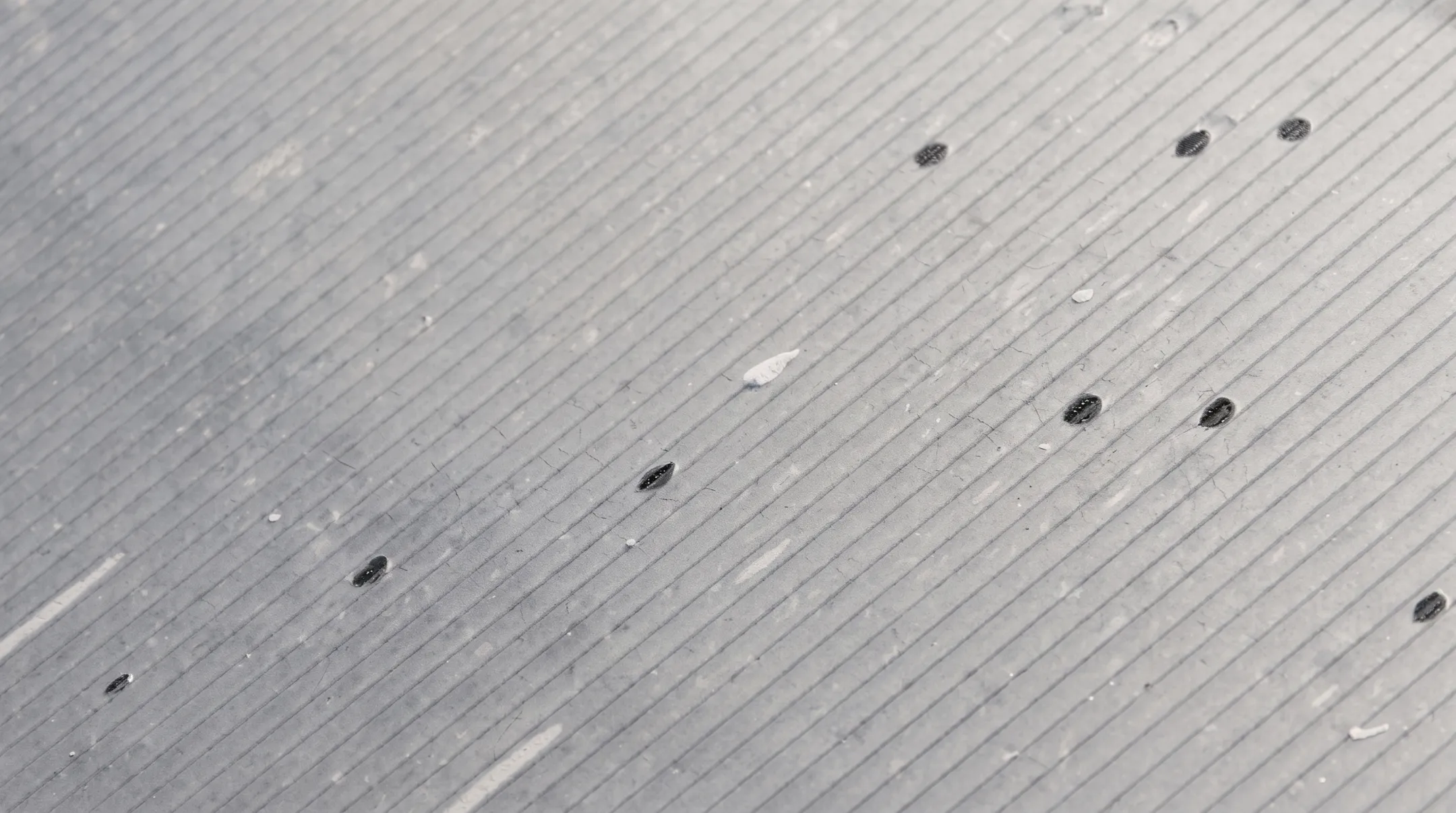 Close-up of hail damage marks on commercial roof membrane surface