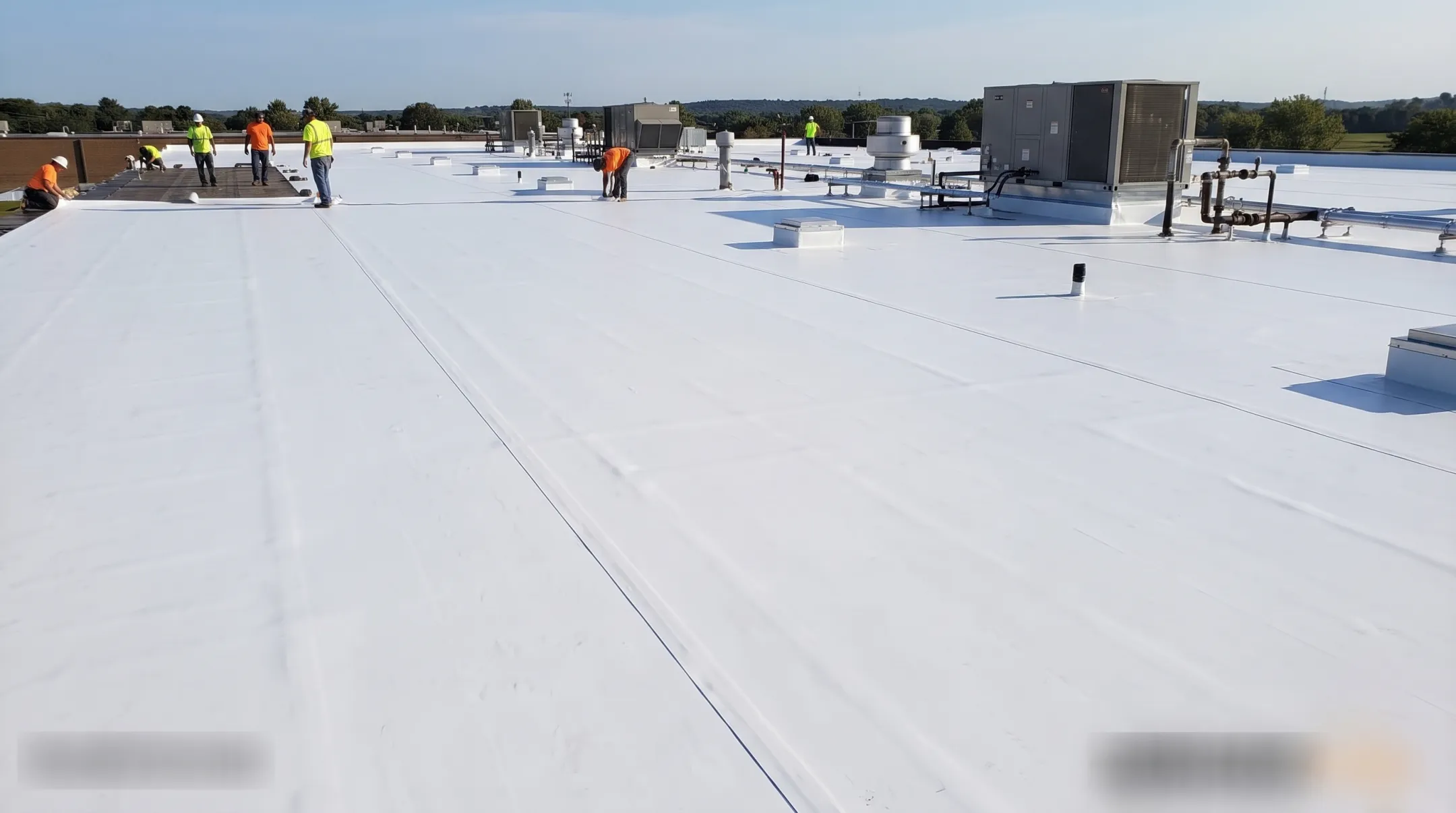 Commercial TPO membrane roofing installation on flat industrial building