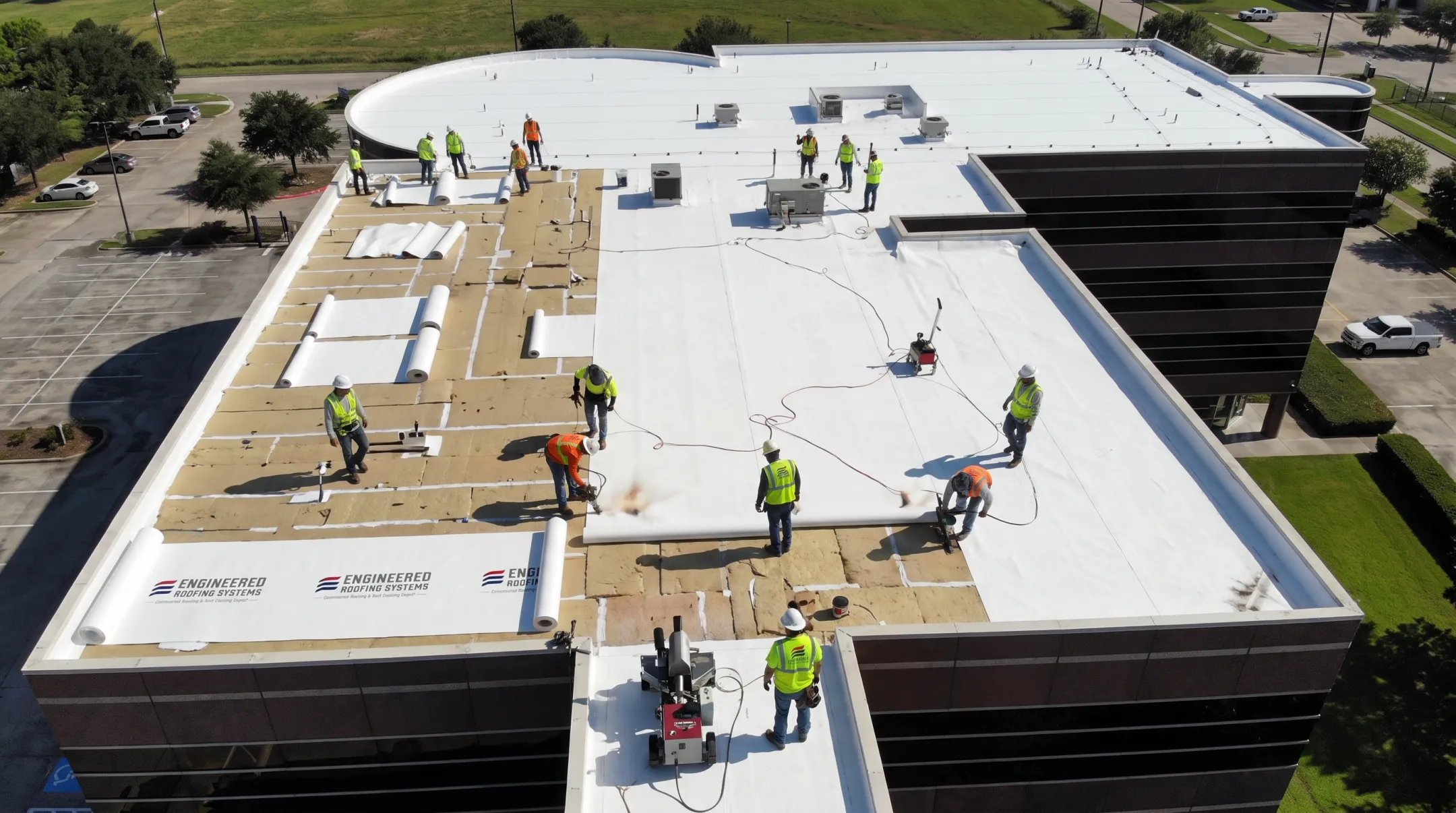 TPO membrane roof installation with heat-welded seams on commercial building