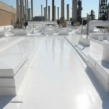Close-up of repaired commercial metal roof panels showing sealed seams and coating application
