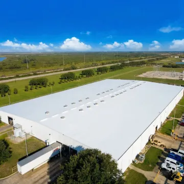 Industrial warehouse with repaired flat roofing system showing quality workmanship