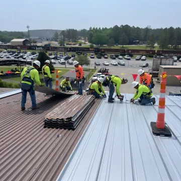 Roofing crew replacing a standing seam metal roof