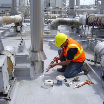Technician repairing a commercial flat roof leak