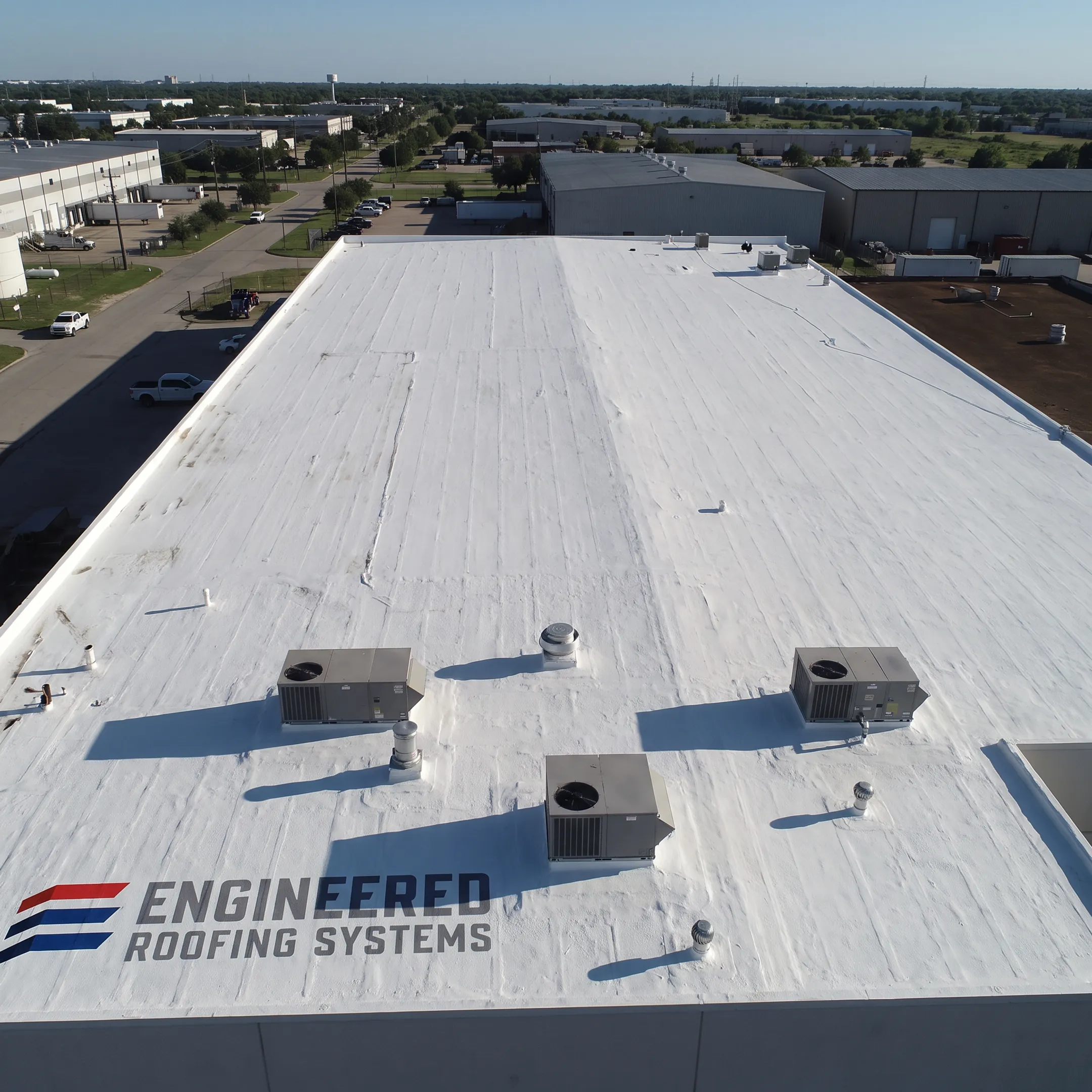 White coated commercial roof with sealed penetrations