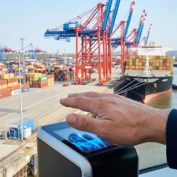 Port worker using contactless palm vein scanner at secure access gate