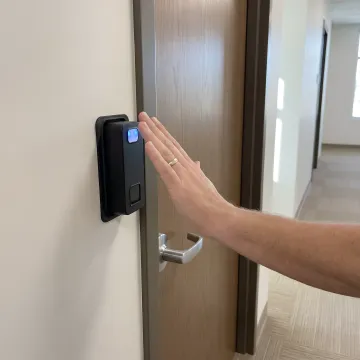 Technician installing a biometric access reader
