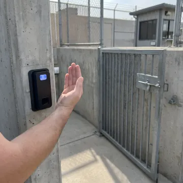 Technician demonstrating biometric gate access control