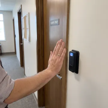 University student using palm vein scanner to access campus building