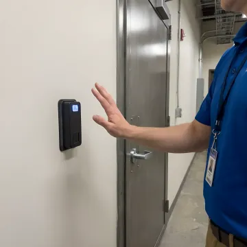 Contactless biometric palm scanner mounted at office building security gate