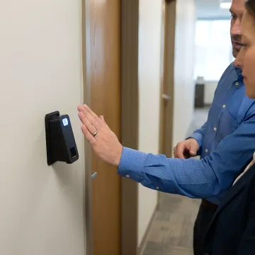 Security consultant reviewing biometric access control system blueprint with facility manager in server room