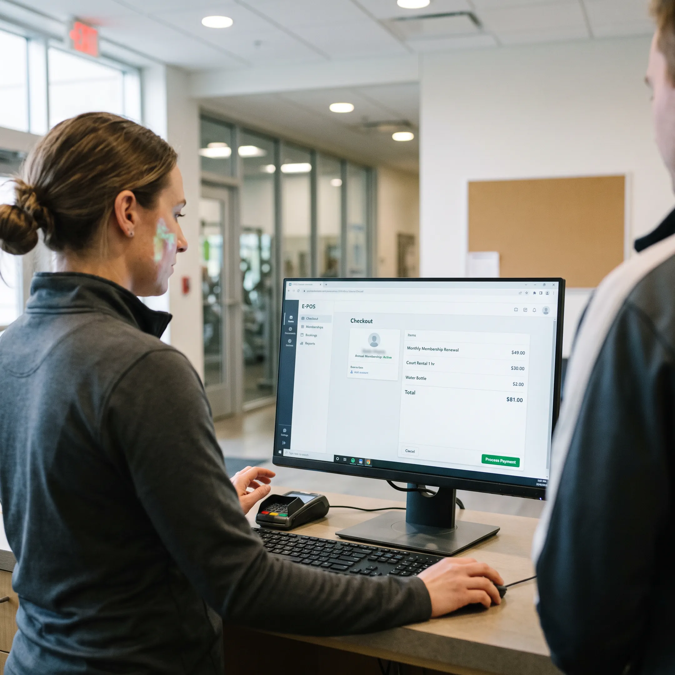 Staff member using E-POS software at a busy recreation facility counter