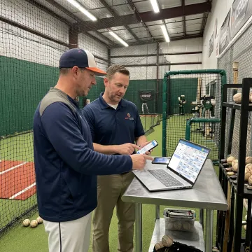 Coach and facility manager reviewing baseball bookings