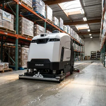 Autonomous commercial floor scrubber cleaning a warehouse