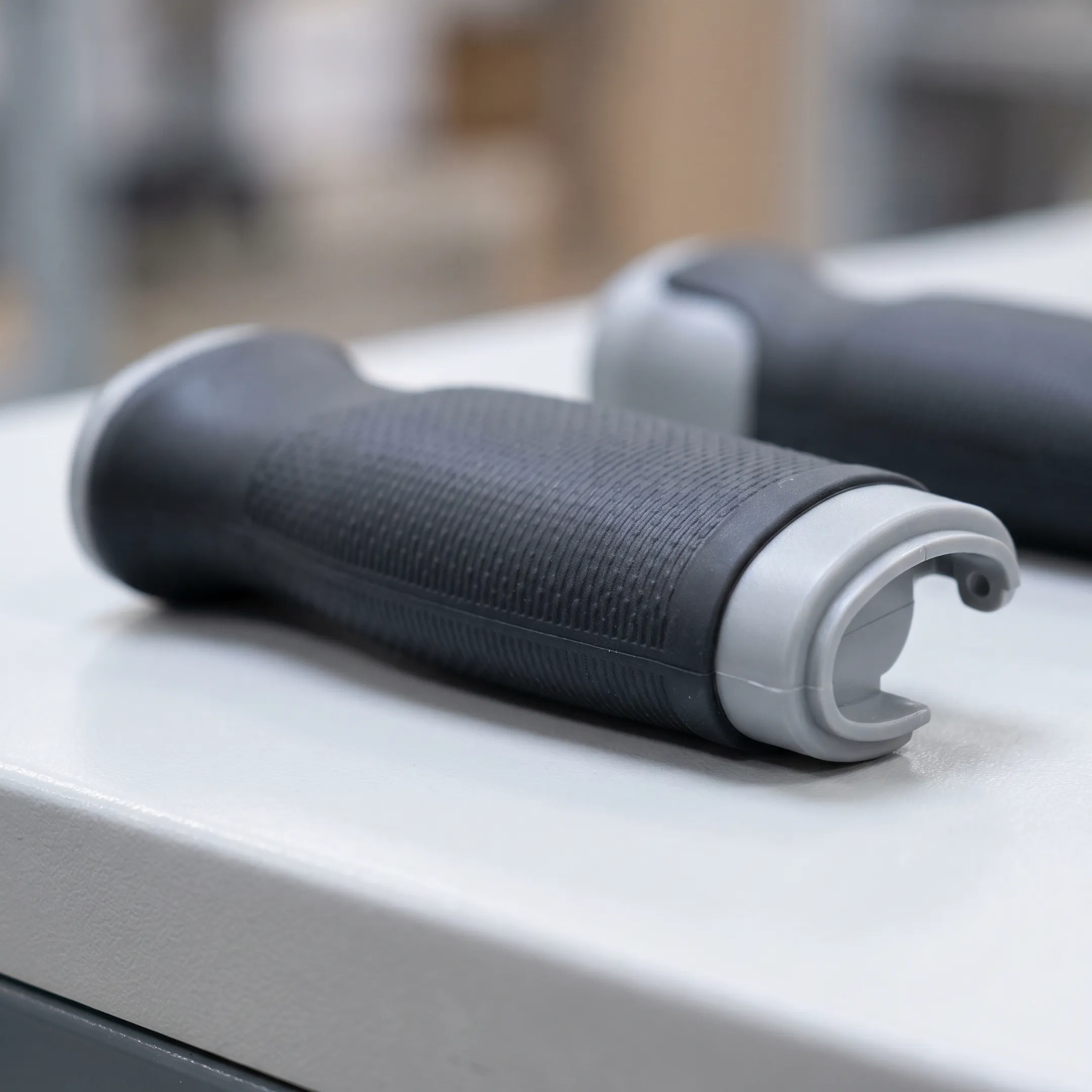 Precision overmolded plastic component showing rubber grip over rigid plastic substrate