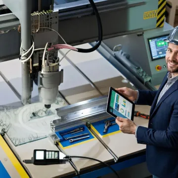 Factory manager reviewing real-time production dashboard on tablet