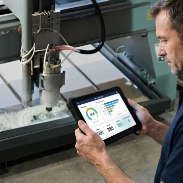 Operator reviewing CNC monitoring software on a tablet