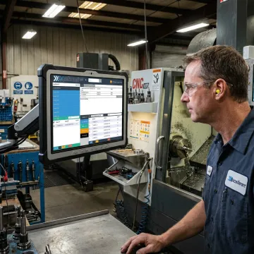 Technician reviewing secure CNC program transfer