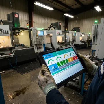 Operator recording idle reason codes at CNC machine