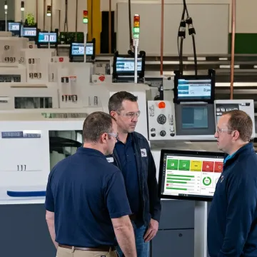 Production team reviewing live shop floor workflow dashboard