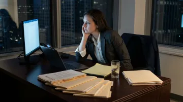 Burned out attorney alone at desk late night in empty law firm office