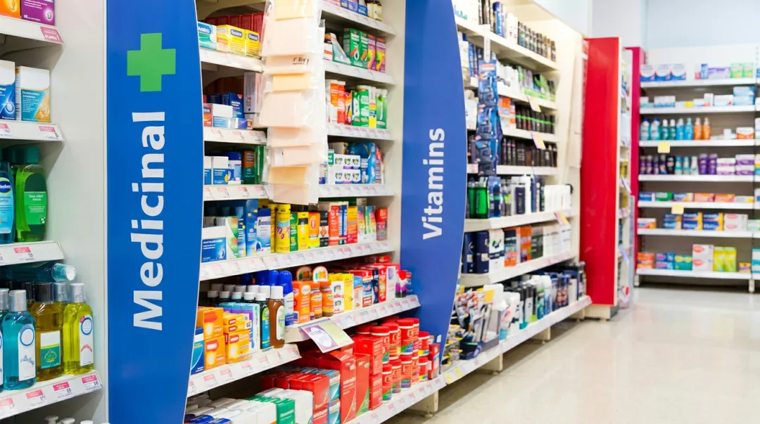 Pharmacy front-end OTC display racks with eye-level product placement and clear category labels