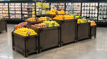 Supermarket bulk display rack filled with fresh produce and promotional items