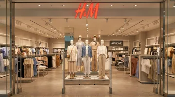 Retail store mannequins styled in complete outfits positioned near store entrance