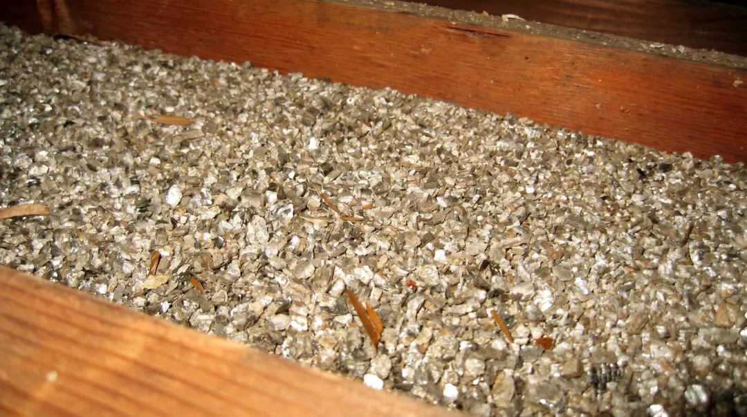 Close-up photo of loose-fill vermiculite insulation showing its pebble-like texture
