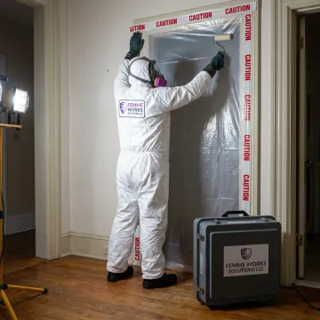 Technician setting up mold containment barrier