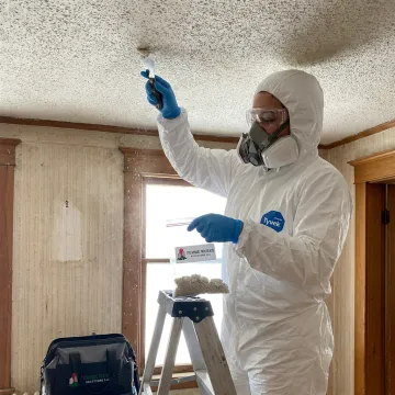 Inspector collecting an asbestos ceiling sample