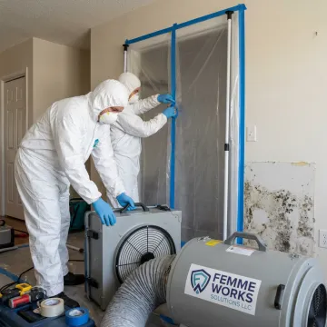 Mold remediation technicians setting up containment