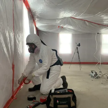 Technician preparing a popcorn ceiling for asbestos removal