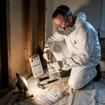 Certified asbestos inspector collecting a material sample