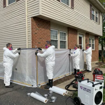 Asbestos removal crew preparing containment