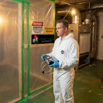 Technician inspecting asbestos containment area