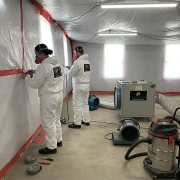 Mold remediation crew setting up containment
