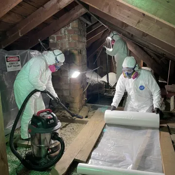 Certified asbestos remediation crew preparing a home for Mass Save insulation upgrades
