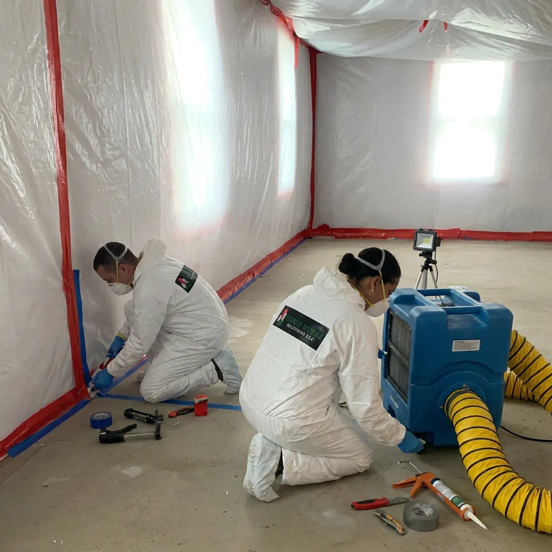Remediation team setting containment before asbestos and mold cleanup