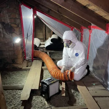 Technician setting up attic containment before insulation removal