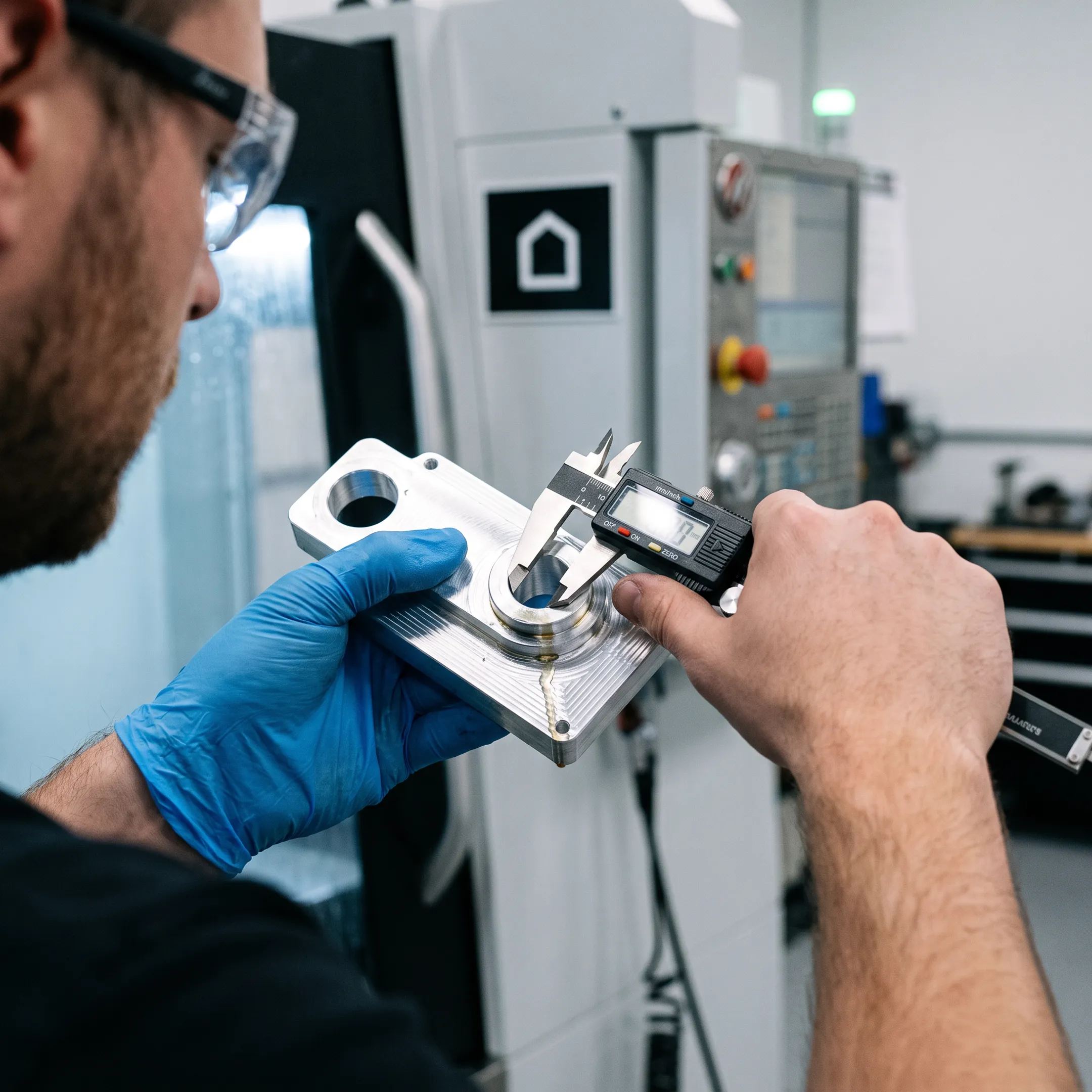 Technician inspecting a precision-machined component