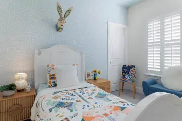 Designer arranging books and decor on custom shelving in elegant home