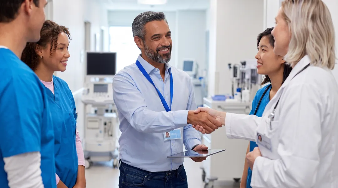 Medical device sales representatives meeting with healthcare professionals in hospital clinical setting