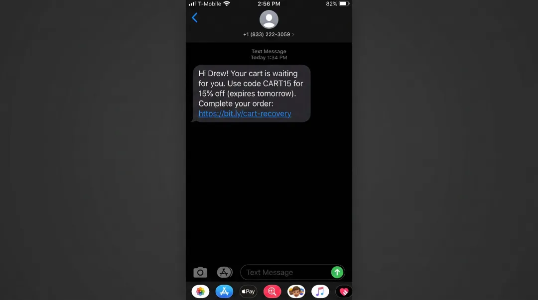 Mobile phone screen displaying abandoned cart SMS message with personalization discount code and direct purchase link