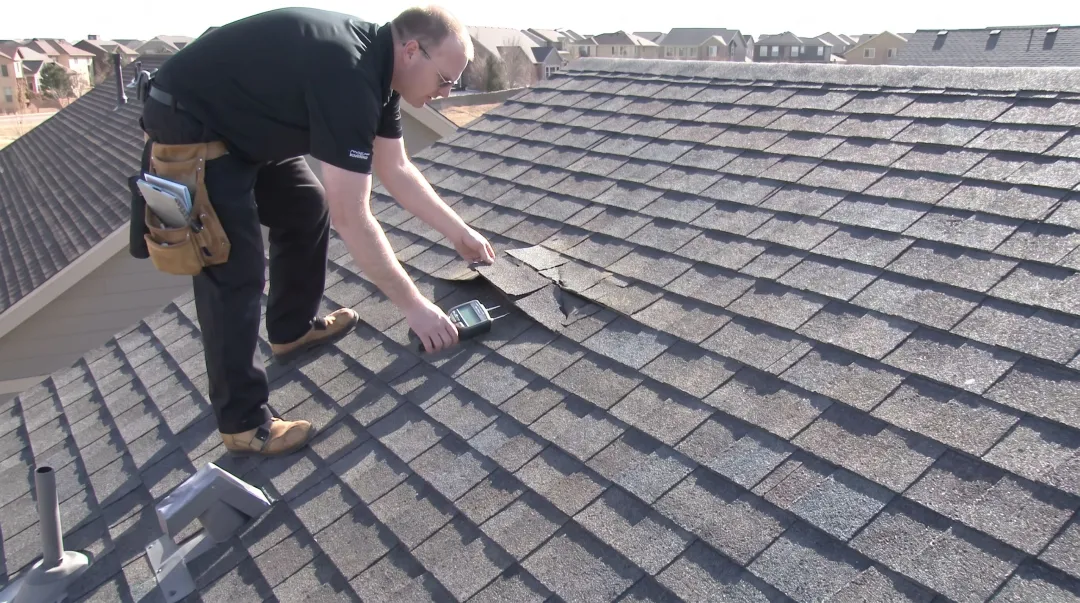 Roofing inspector examining damaged shingles and sagging roof deck