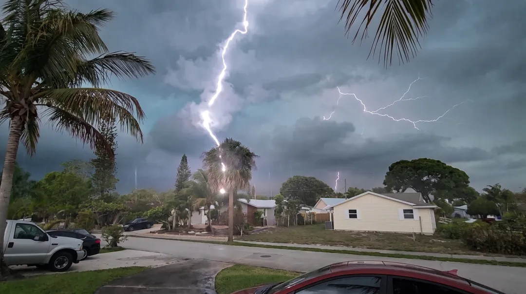 Thunderstorm clouds with lightning striking over South Florida residential neighborhood