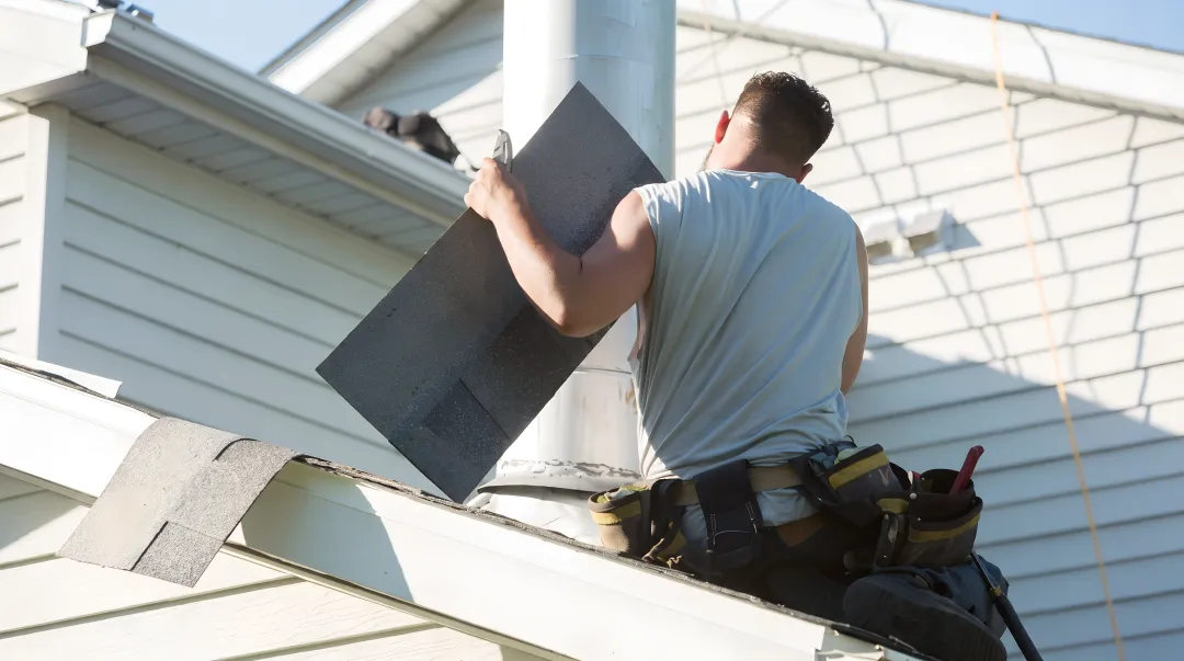 Fortress Roofing Systems inspector examining shingle damage on residential roof