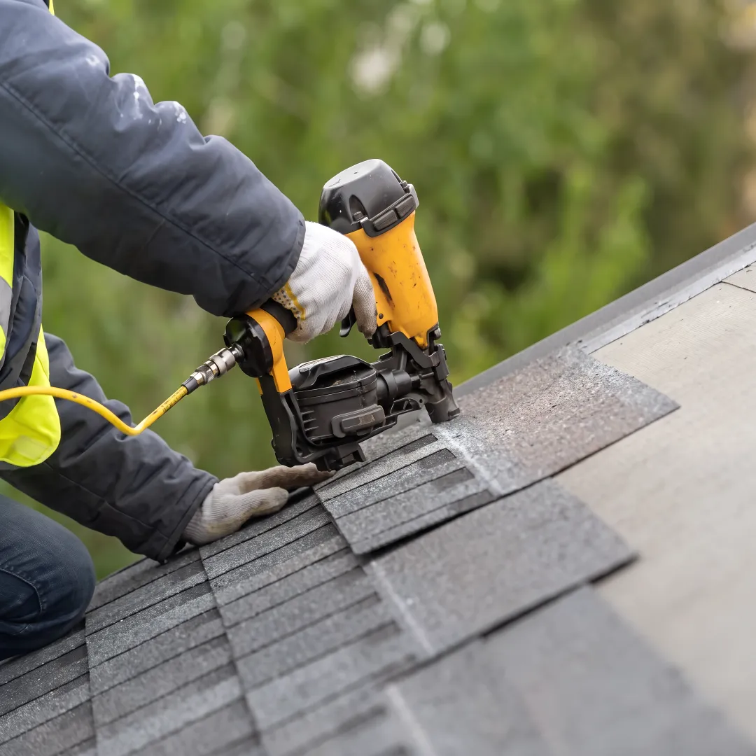 Roofer installing durable shingles on a home