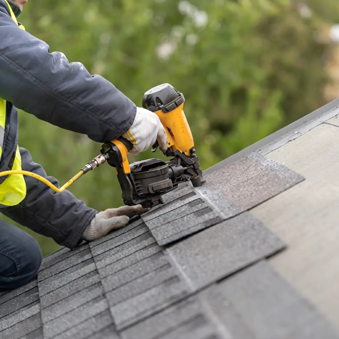 Roofing professional inspecting storm-resistant shingles