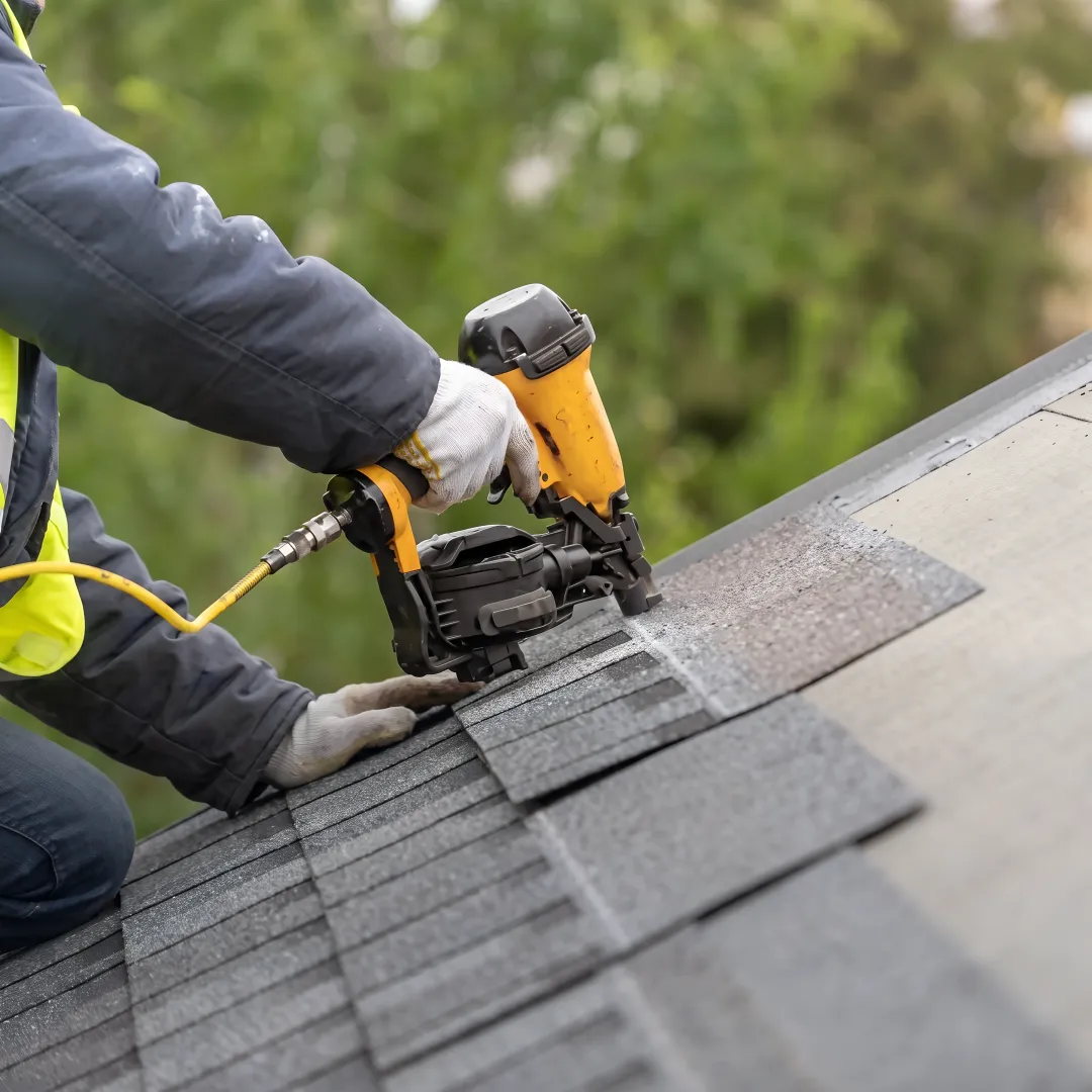 Roofers installing reflective shingles on a home